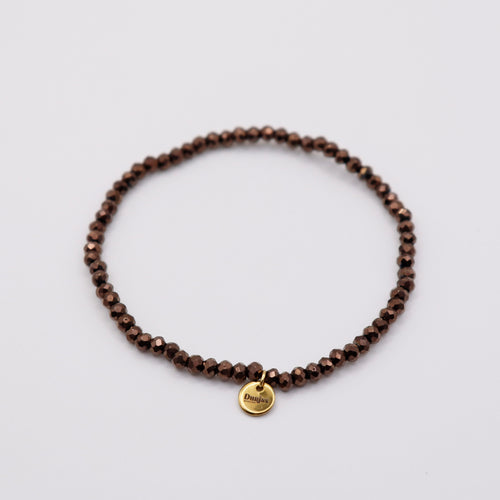 Elastisches Armband mit dunkelbraunen Glasperlen und goldenem Dunjas Atelier Charm, handgemacht in Zürich