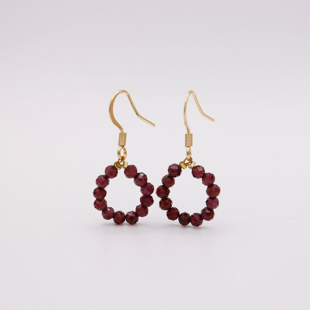 Ohrhaken mit Granat – tiefroter Granatperlen-Kreis auf goldenem Edelstahlhaken, handgemacht in Dunjas Atelier Zürich
