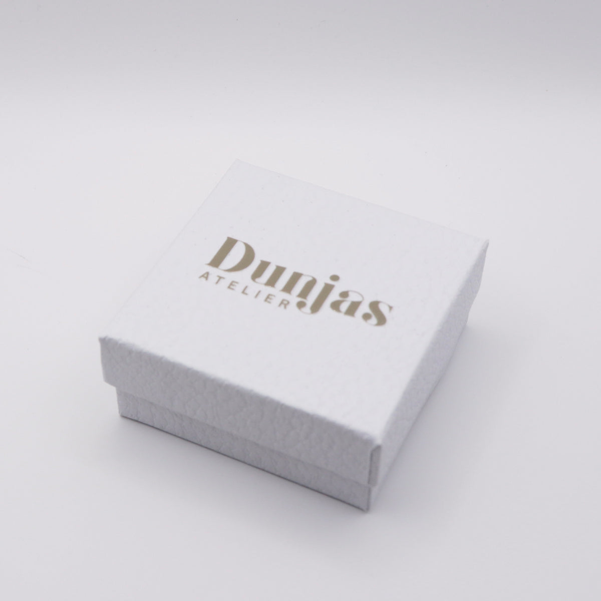 Weisse Geschenkbox mit goldenem Dunjas Atelier Schriftzug – Verpackung für Ohrhaken mit Sonnenstein
